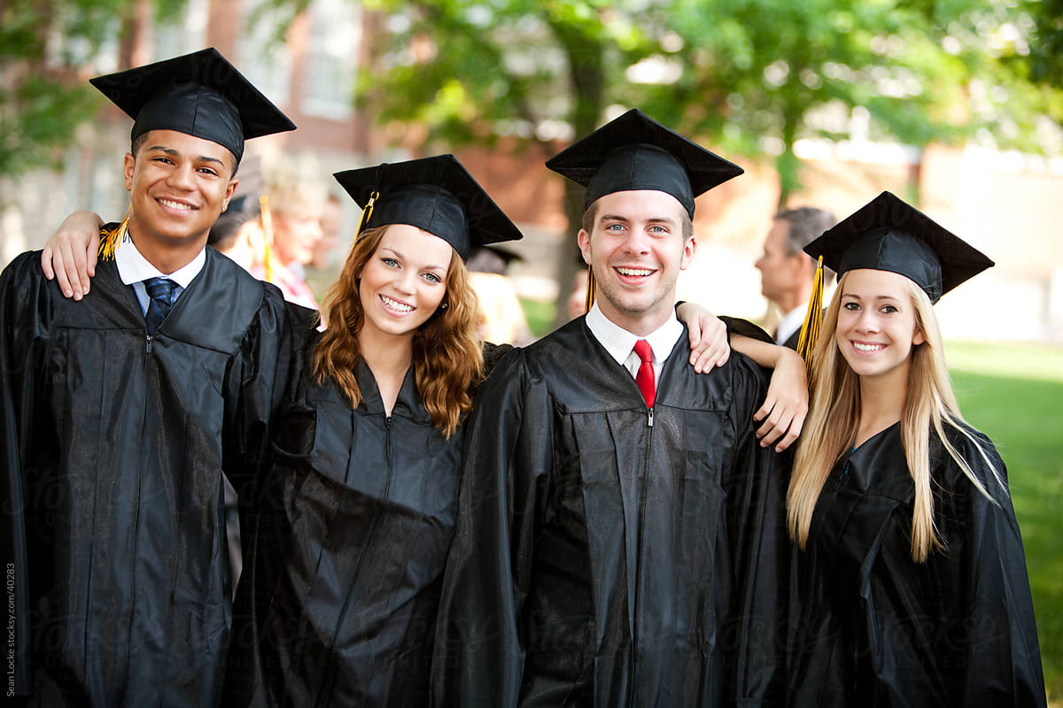 Four graduating college students wearing their black cap and gown