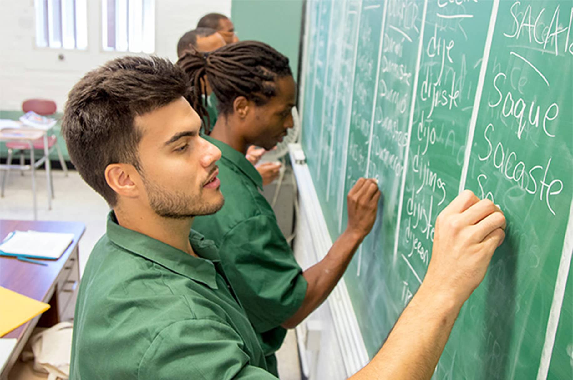 Students who are pursuing a college degree through Bard College's Prison Initiative are writing on the board