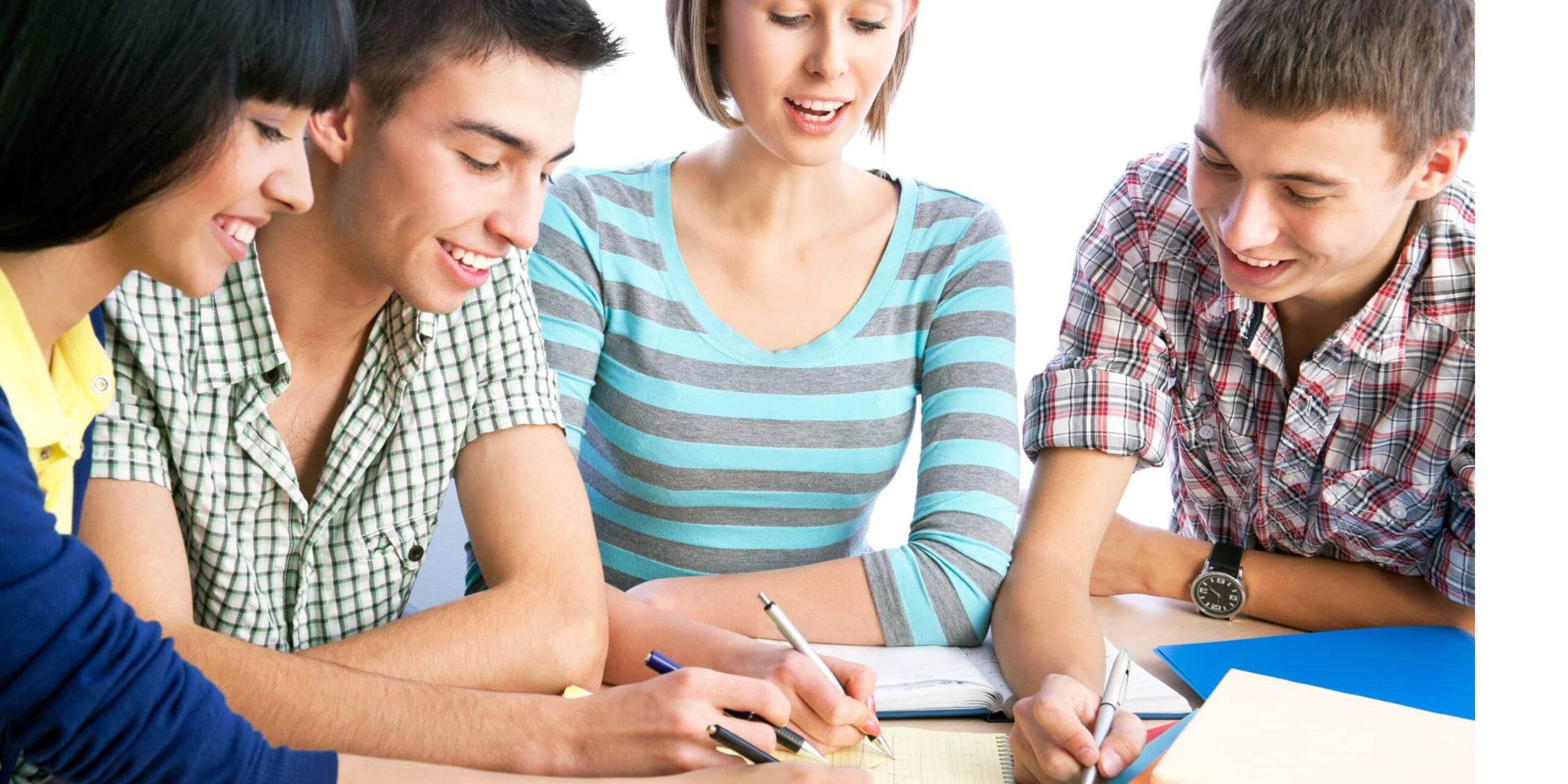 A group of four young students studying together in classroom