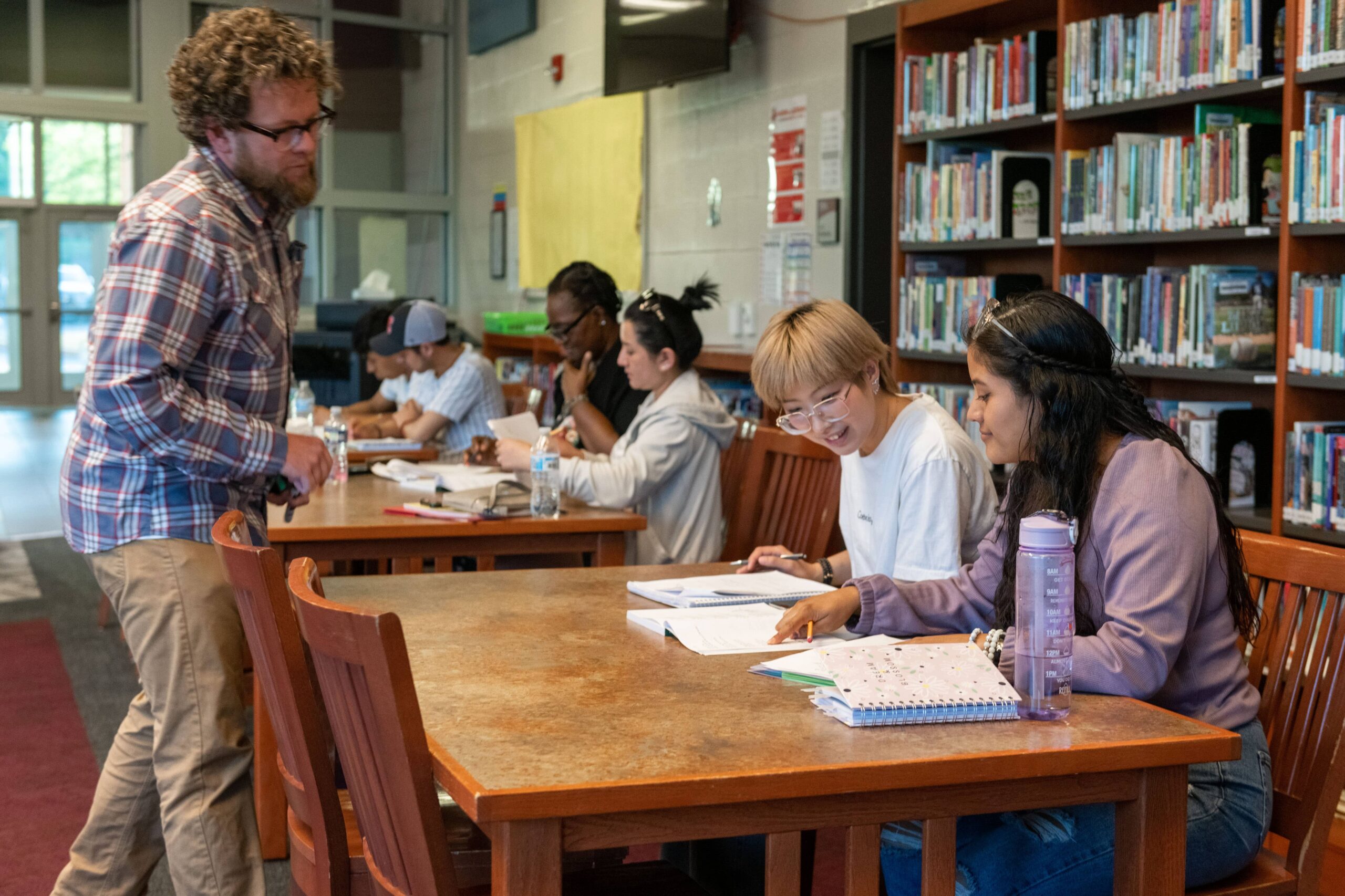 Students in classroom with a tutor overseeing their work