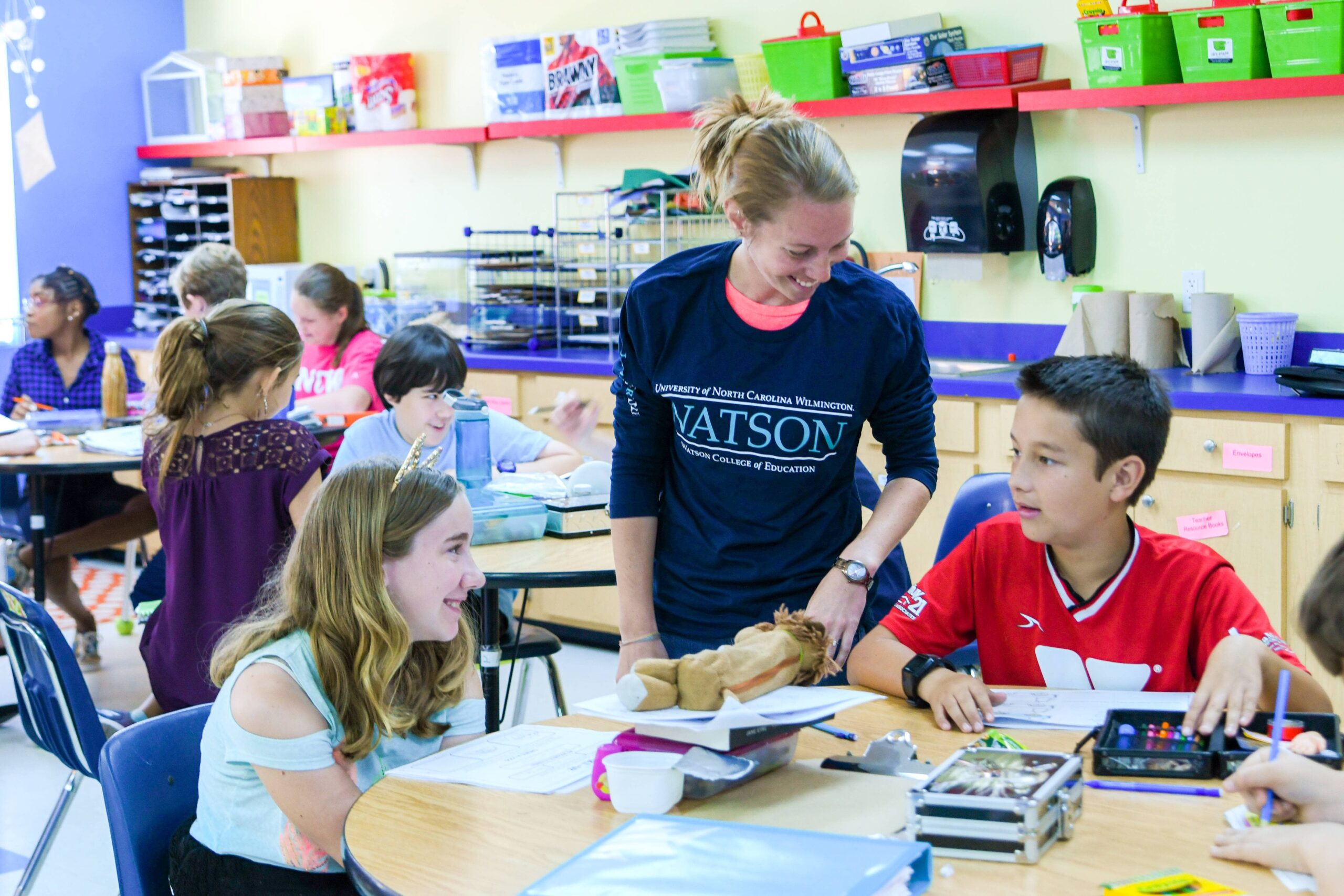 A teacher assistant working with students in classroom