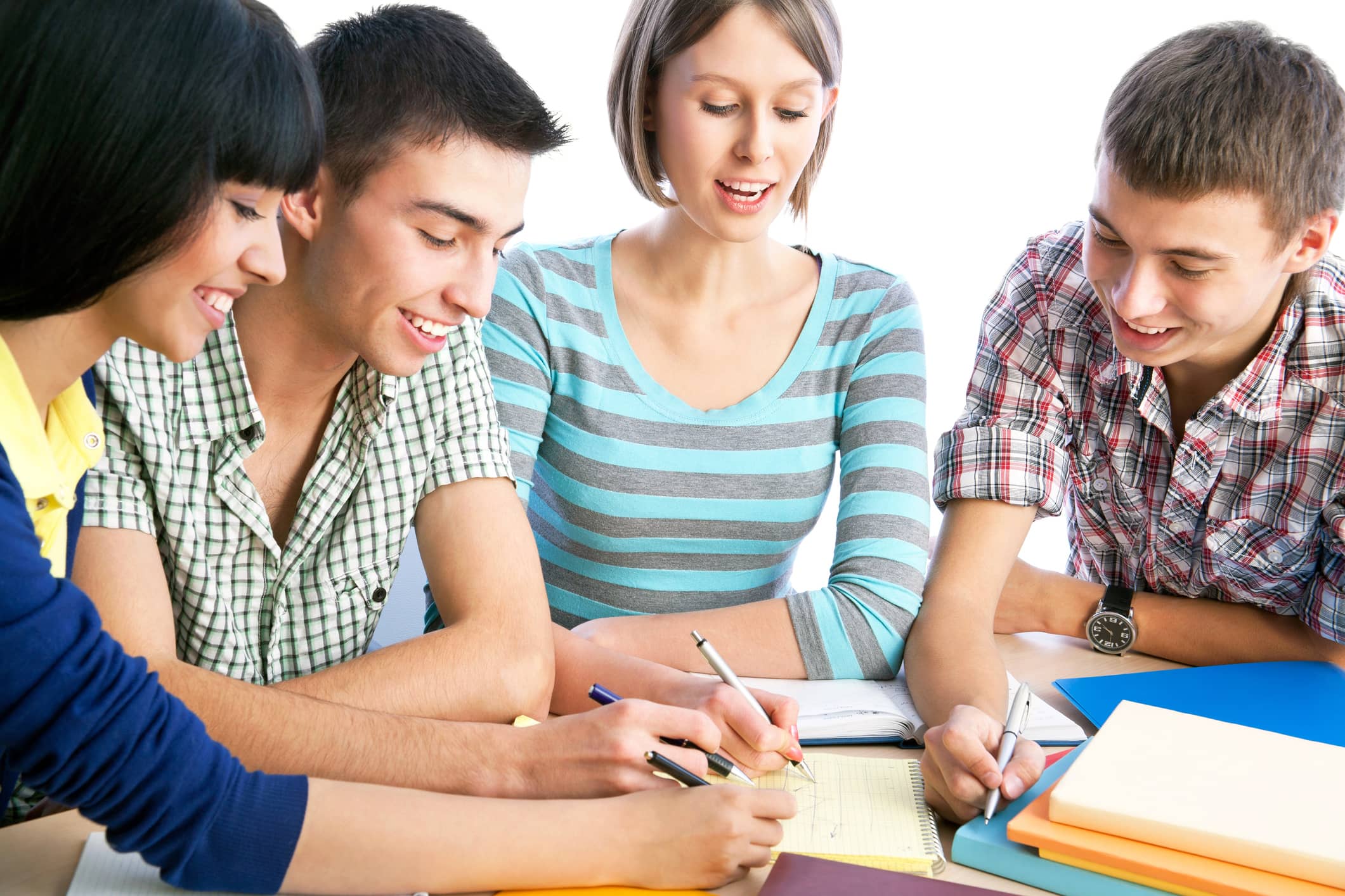 A group of four young students studying together in a classroom