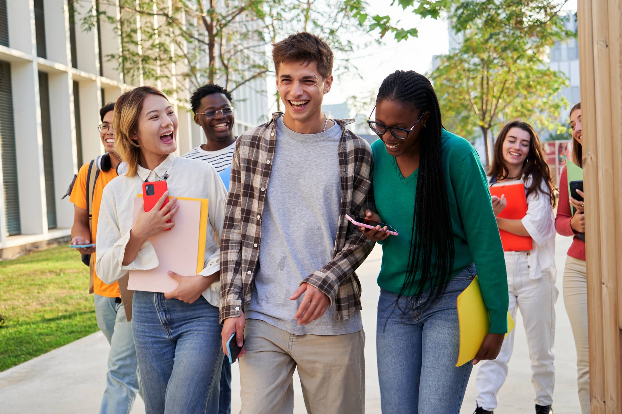 A diverse and cheerful group of students walking together on college campus