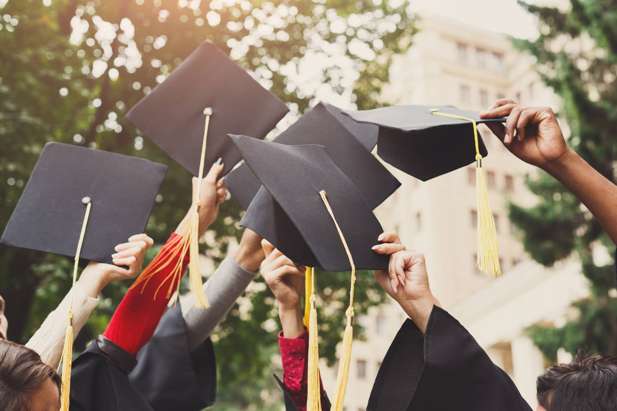 A group of college students celebrating their graduation by throwing caps in the air